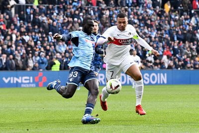 Paris Saint-Germain's Kylian Mbappé and AC Le Havre's Arouna Sanganté battle for the ball